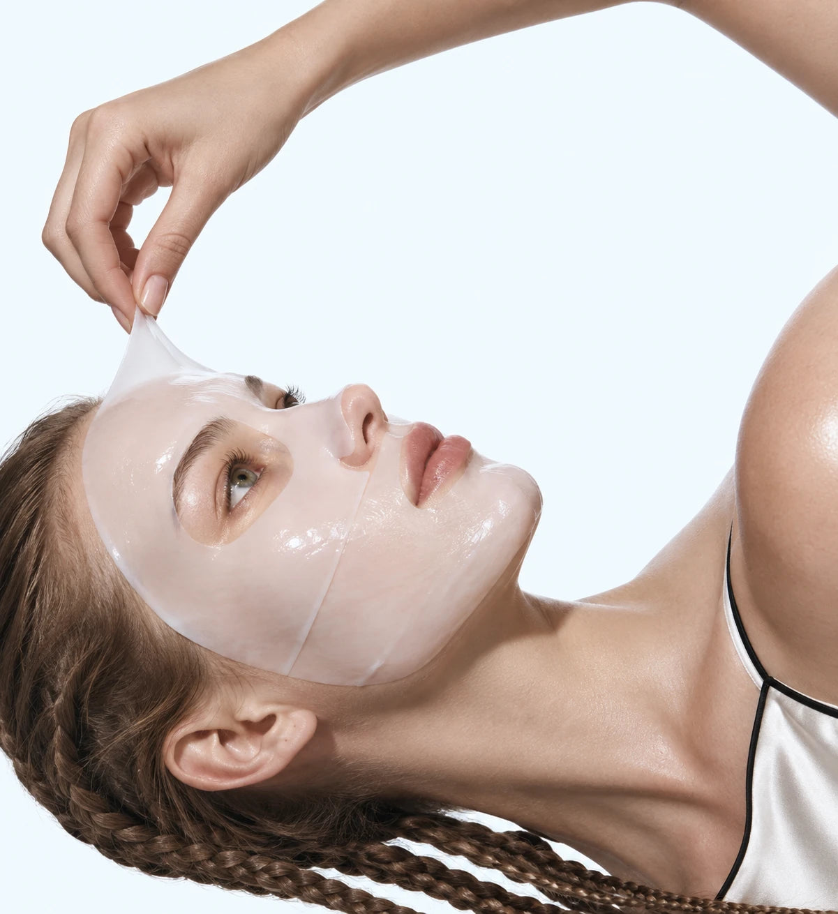 Woman gently peeling a face mask away from her forehead