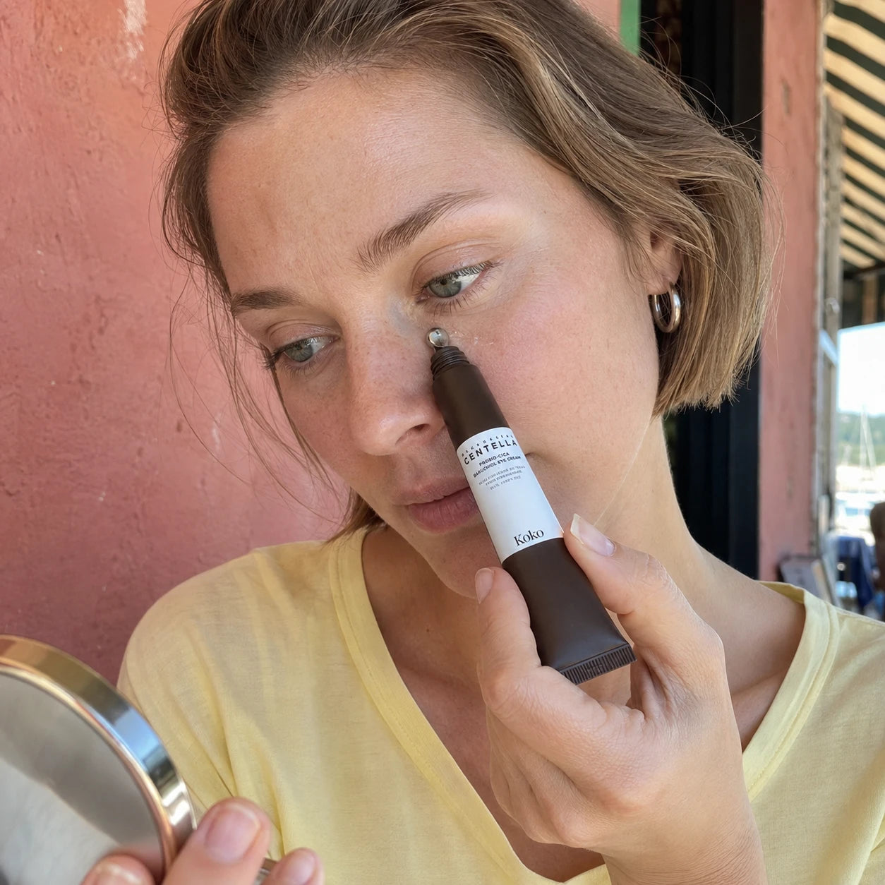 Koko campaign: applying Peptide Eye Repair outside a cafe
